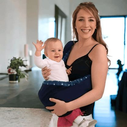 Jeune maman souriante portant son bébé dans un porte bébé de hanche, porte bébé d’épaule, pratique pour un portage confortable à la maison.